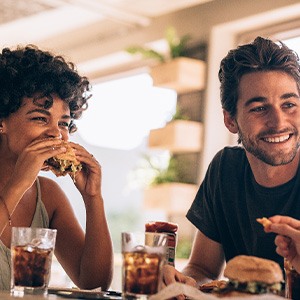 Friends smiling while eating lunch at restaurant