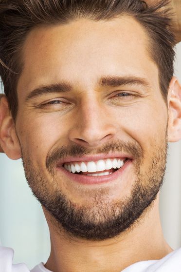 Young man with short facial hair smiling