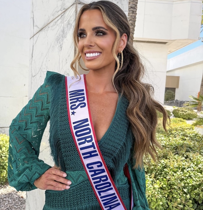 Doctor Lundgren in a red slip dress and a Miss North Carolina sash