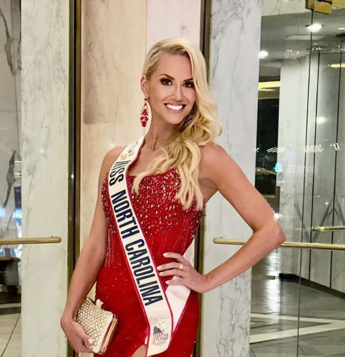 Doctor Lundgren in a red slip dress and a Miss North Carolina sash
