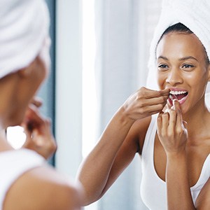 Woman smiling while flossing her teeth