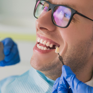 Man with a missing tooth smiling in the dental chair