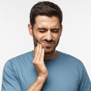 Man holding his cheek in pain