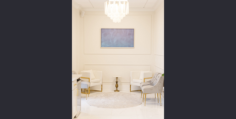 Chairs in the waiting area with a chandelier-like light hanging from the ceiling
