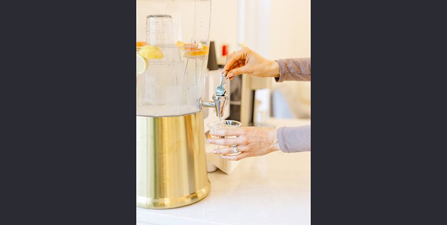Person getting a cup of water from a watercooler