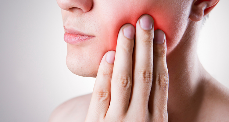 Person holding their jaw in pain needing TMJ treatment in Wilmington