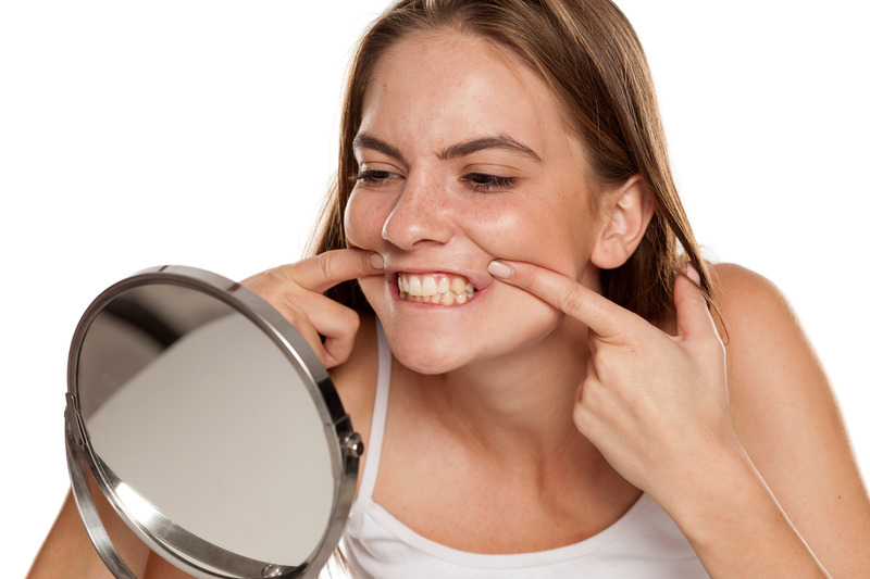 Patient looking in mirror after cosmetic dentistry on small teeth