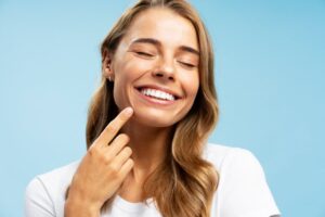 Woman smiling and pointing to her teeth